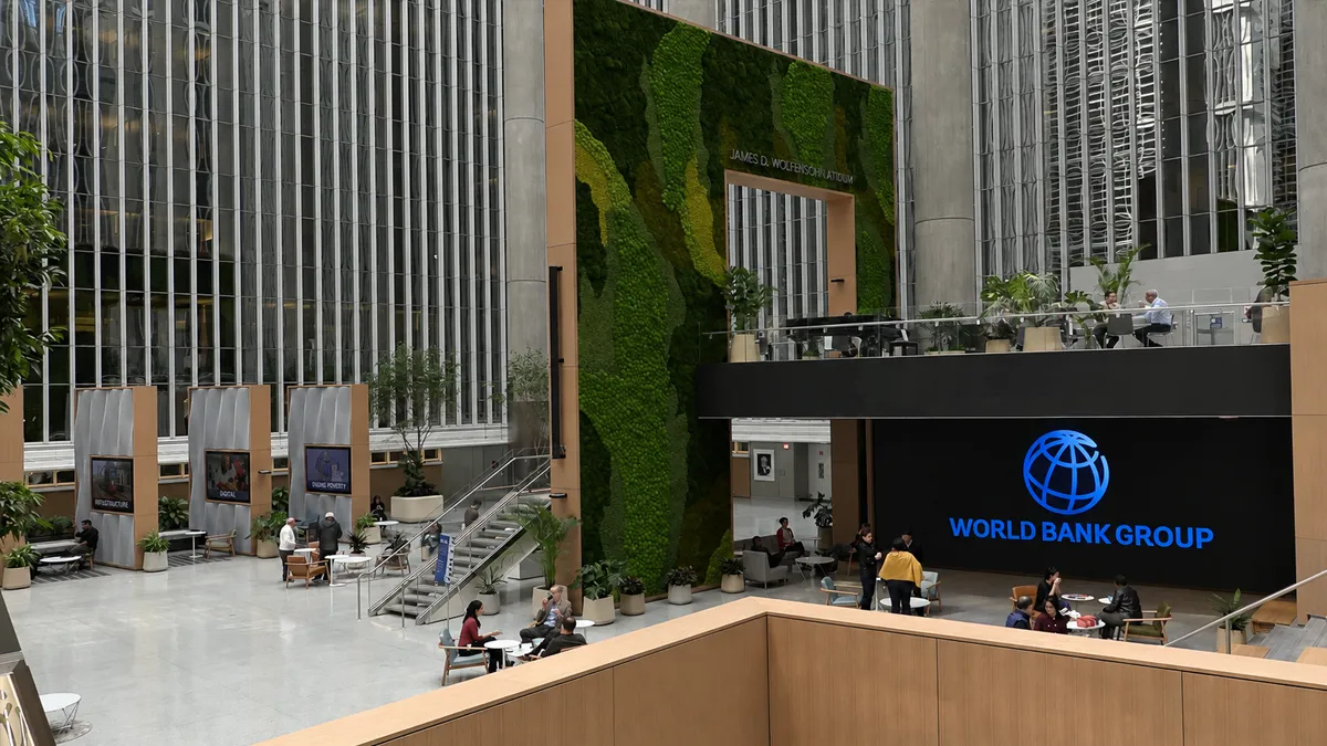 World Bank Video Still Still clip of a corporate video for World Bank Group showing their giant lobby area with a indoor waterfall and greenery. People are situated throughout talking business.